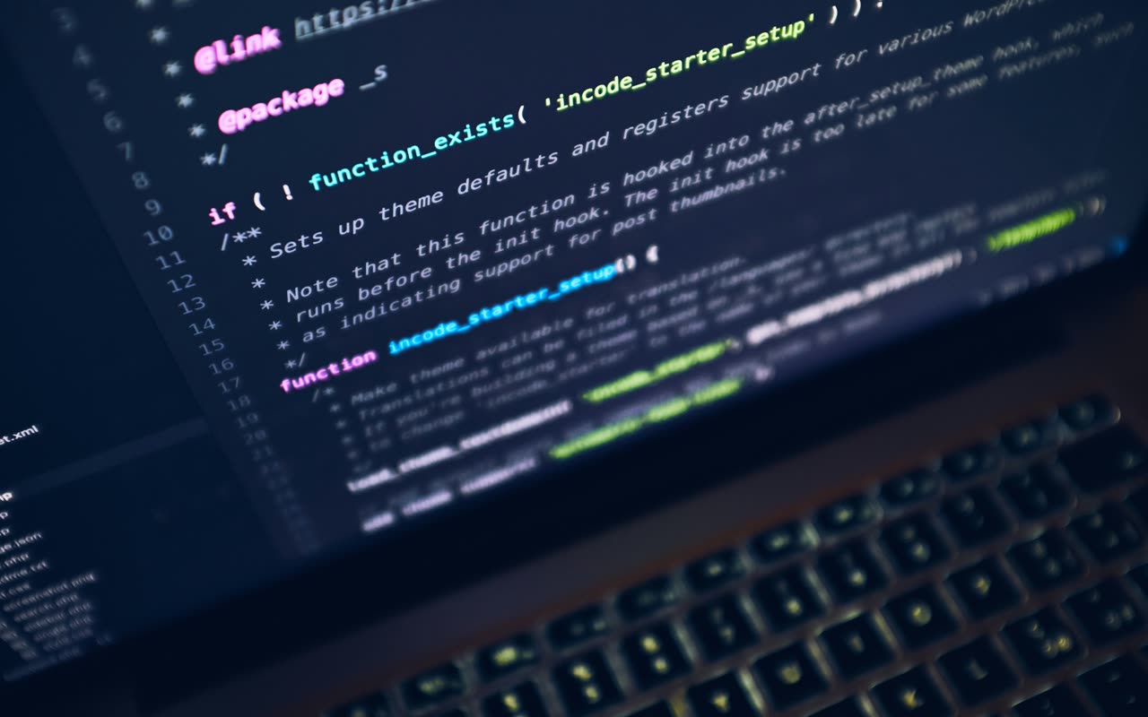 Editor de código exibido em um monitor em um ambiente escuro.